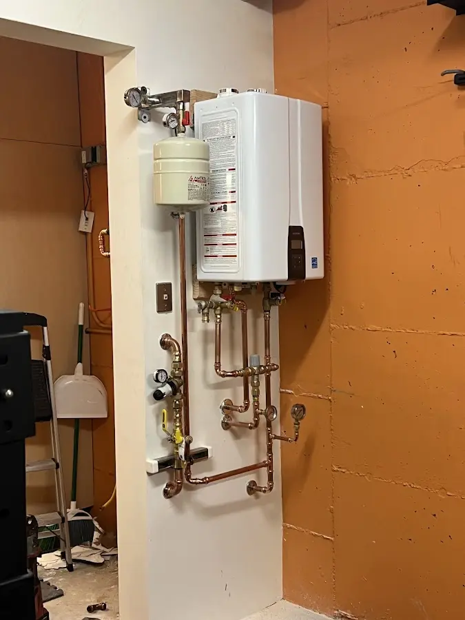 Plumbing technician inspecting water heater connections in Marshall